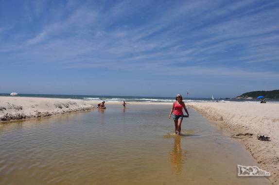 Caminhando no pequeno canal que liga a lagoa ao mar, na Praia do Rosa, litoral sul de Santa Catarina